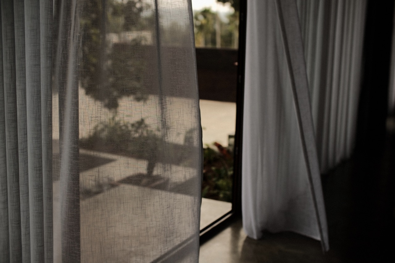 Sheer curtains drifting at an open door onto the terrace