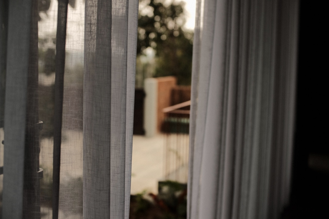 Soft focus through layered sheer curtains to the garden beyond