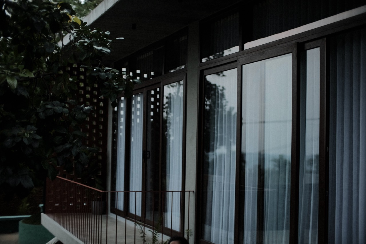 The house seen at dusk, warm light in the upper windows