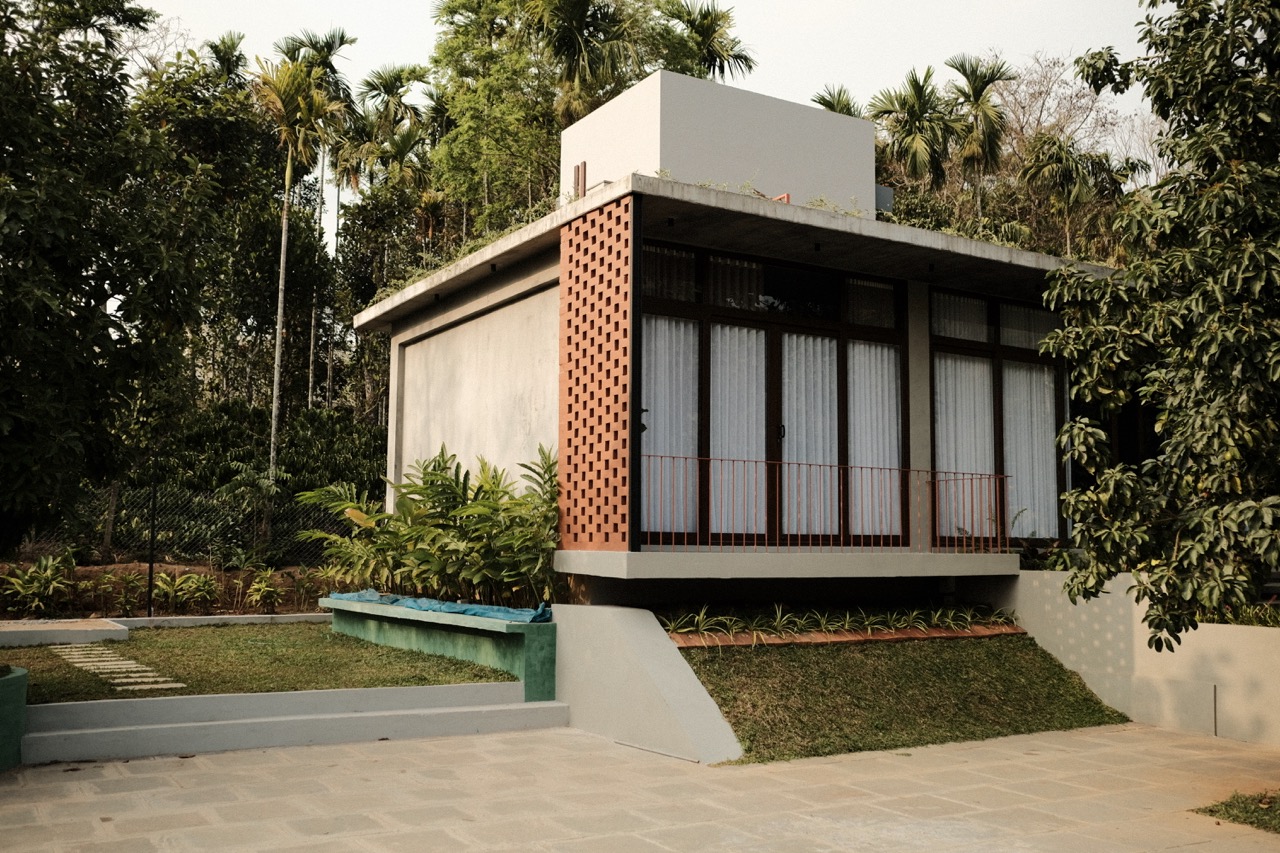 The house seen from the courtyard, terracotta jali screen wrapping its corner