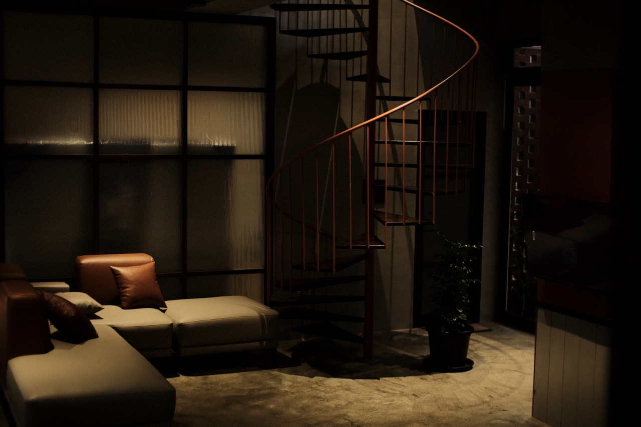 The living area at night, the spiral stair lit warmly