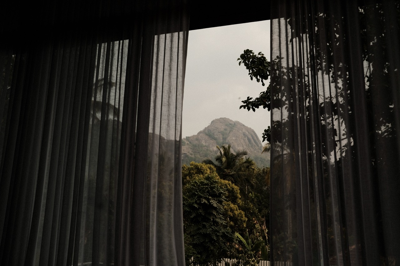 The rocky cliffs of the Edakkal Hills framed between dark curtains